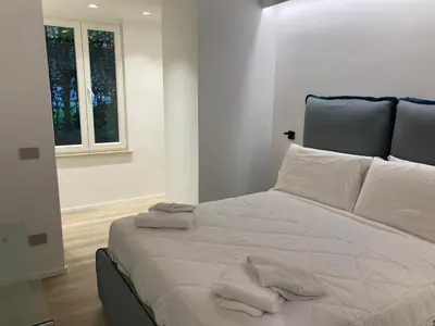 a bedroom with a large white bed with towels on it at Manzoni bilocale con doppi servizi piano terra in Rome