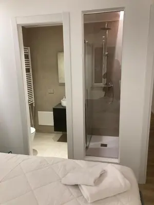 a bathroom with a shower and a bed in a room at Manzoni bilocale con doppi servizi piano terra in Rome