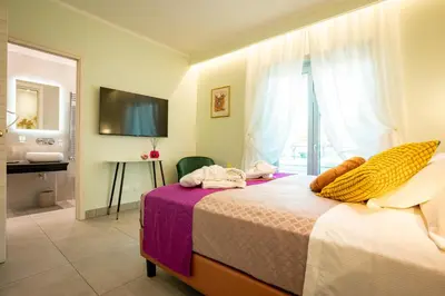 a bedroom with a bed and a bathroom with a window at Twins Royal Suite in Rome