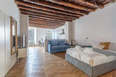 a bedroom with a large bed and a blue couch at Iflat Cozy Studio in the Heart of Campo de Fiori in Rome