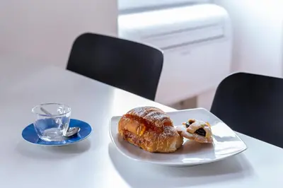 a white plate with a pastry on a table at Iflat Cozy Studio in the Heart of Campo de Fiori in Rome