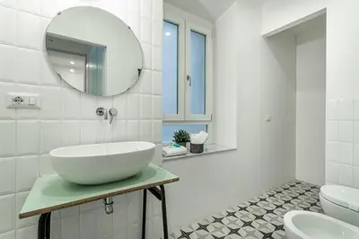 a white bathroom with a sink and a mirror at Iflat Cozy Studio in the Heart of Campo de Fiori in Rome