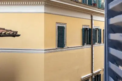 a yellow building with green shuttered windows at Iflat Cozy Studio in the Heart of Campo de Fiori in Rome