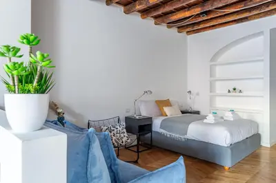 a bedroom with a bed and a chair at Iflat Cozy Studio in the Heart of Campo de Fiori in Rome