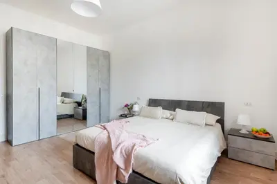 a white bedroom with a large bed and a living room at Luxury Pink apartment in Rome