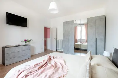 a bedroom with a bed and a tv on a wall at Luxury Pink apartment in Rome