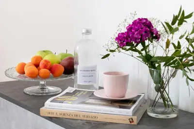 a table with a vase of fruit and a bottle of milk at Luxury Pink apartment in Rome