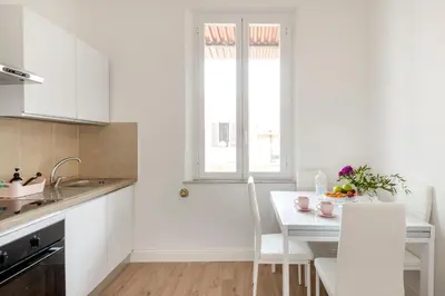 a white kitchen with a table and a window at Luxury Pink apartment in Rome