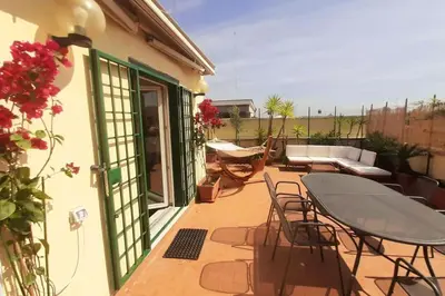 a patio with a table and chairs on a balcony at Amazing studio with terrace in Rome