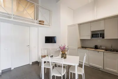 a kitchen and dining room with a white table and chairs at Casina Bianca in Rome