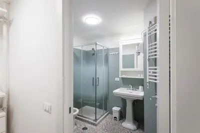 a bathroom with a glass shower and a sink at Casina Bianca in Rome