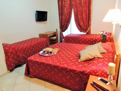 a hotel room with two beds and a plate of food on the bed at Florida rooms - comfort Hotel in Rome