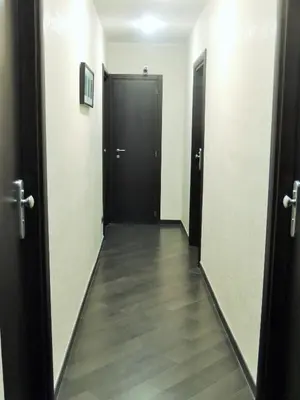 a hallway with two black doors and a wooden floor at Florida rooms - comfort Hotel in Rome