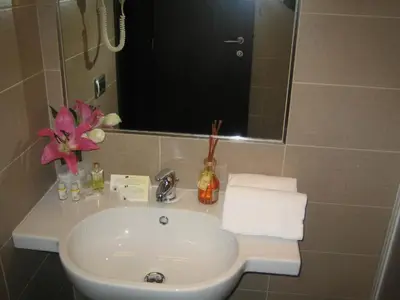 a white sink in a bathroom with a mirror at Florida rooms - comfort Hotel in Rome