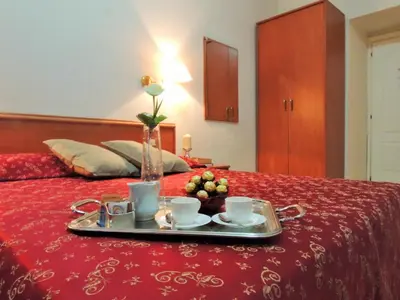 a tray with two cups and fruit on a bed at Florida rooms - comfort Hotel in Rome