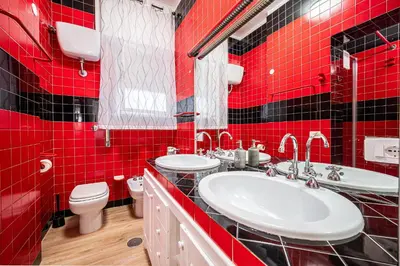 a red tiled bathroom with two sinks and a toilet at Anna Vatican Loft - Relax al centro di Roma! in Rome