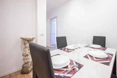 a dining room with a table with white plates and chairs at Anna Vatican Loft - Relax al centro di Roma! in Rome