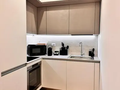 a kitchen with white cabinets and a sink at Rome Riverside Retreat in Rome
