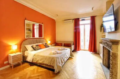 a bedroom with orange walls and a bed and a tv at Domus Mazzini in Rome