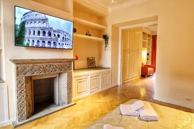 a living room with a fireplace and a tv on the wall at Domus Mazzini in Rome