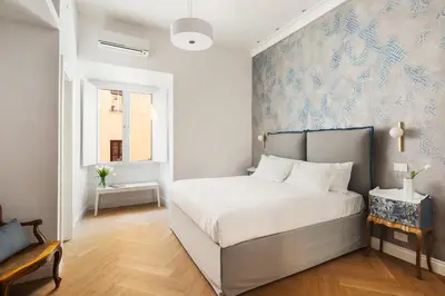 a bedroom with a bed with a blue and white wallpaper at Iflat New Spacious & Classy Apartment in Monti in Rome