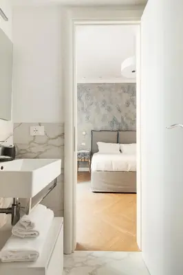 a bedroom with a bed and a sink and a mirror at Iflat New Spacious & Classy Apartment in Monti in Rome