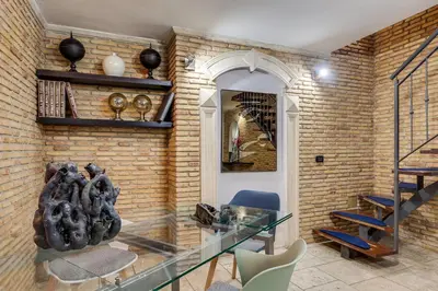a room with a glass table and a brick wall at Oliviero - Piazza Navona Apartment in Rome