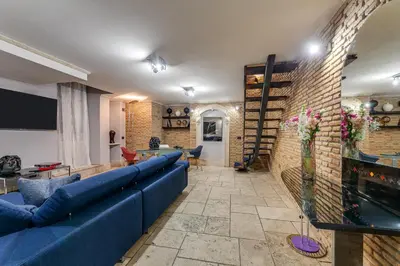a living room with a blue couch and a brick wall at Oliviero - Piazza Navona Apartment in Rome