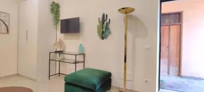 a living room with a green ottoman and a lamp at Roma Brancaleone Loft, Metro C in Rome