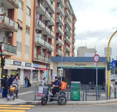 a man on a bike at a bus stop on a street at Roma Brancaleone Loft, Metro C in Rome