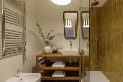 a bathroom with a sink and a mirror at Tiberim Lux Penthouse City View in Rome