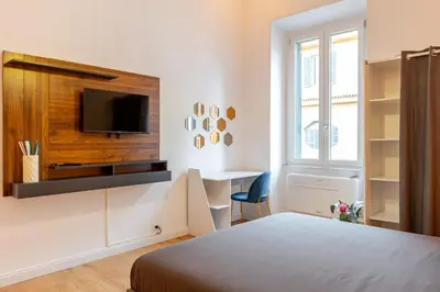 a bedroom with a bed and a desk and a tv at Domus Adriana Ada - adiacente metro A in Rome