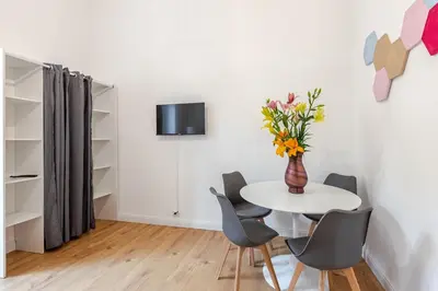 a white table with chairs and a vase with flowers at Domus Adriana Ada - adiacente metro A in Rome