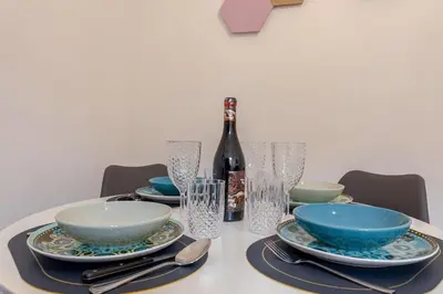 a table with plates and bowls and a bottle of wine at Domus Adriana Ada - adiacente metro A in Rome