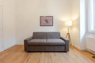a chair sitting in a living room next to a lamp at Domus Adriana Ada - adiacente metro A in Rome