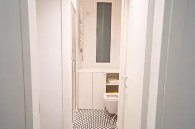 a white bathroom with a toilet and a mirror at Monti Elite House in Rome