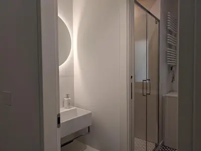 a white bathroom with a sink and a mirror at Monti Elite House in Rome