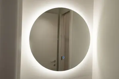 a round mirror on a wall with a door at Monti Elite House in Rome