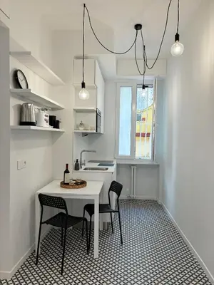 a white kitchen with a table and chairs in it at Monti Elite House in Rome