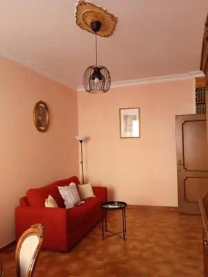 a living room with a red couch and a table at Chez Michel in Rome