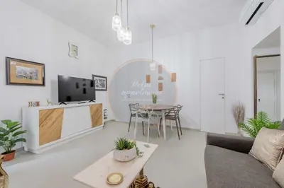 a white living room with a table and a tv at Imperial Luxury in Rome