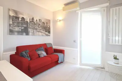a red couch in a living room with a window at Casa di Lola Metro Conca d' Oro in Rome