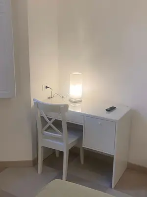 a white desk with a lamp and a chair at The Prince Suite in Rome
