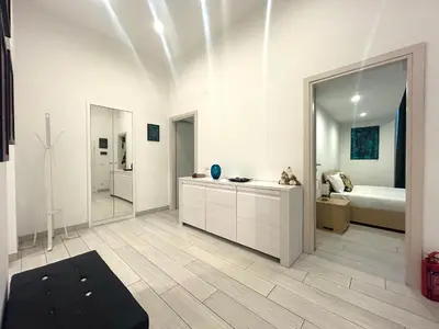 a large white room with a bed and a mirror at Statilia Urban Retreat in Rome