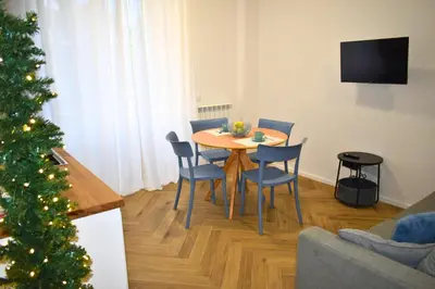 a living room with a table and chairs and a christmas tree at Dimora Artis by Gialel in Rome