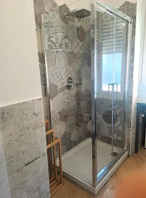 a shower in a room with a stone wall at Elegance Penthouse 959 in Rome
