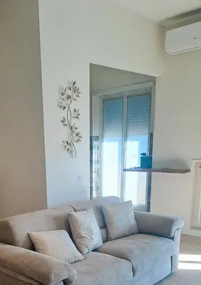 a living room with a couch in front of a window at Elegance Penthouse 959 in Rome