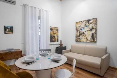 a living room with a table and a couch at L'Arte Dei Sogni Apartment With Terrace- Trastevere District in Rome