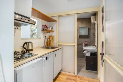 a small kitchen with white cabinets and a sink at L'Arte Dei Sogni Apartment With Terrace- Trastevere District in Rome