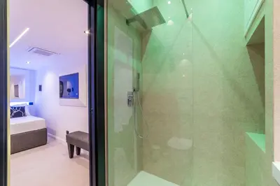 a bathroom with a shower with a glass door at JOIVY Borghese Luxury Suite in Rome